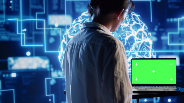 Developer using green screen laptop to implement artificial intelligence parallel processing, breaking up complex computational tasks enabling AI systems to process more input data faster