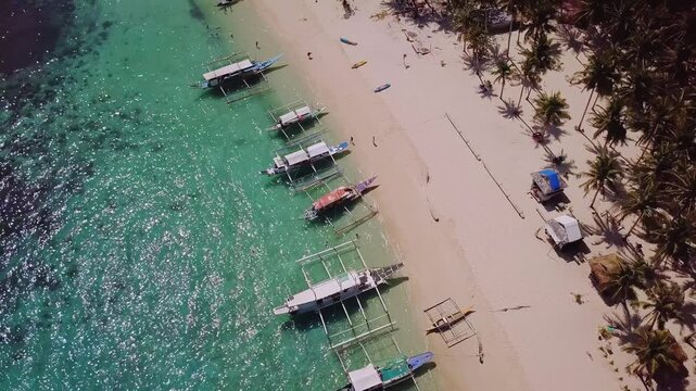 Seven Commandos beach, Palawan. Aerial view of beautiful white sand beach, with palm trees and filipino boats in Siete Pecados Beach, The Philippines. 