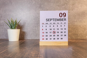Close up of a wooden perpetual calendar showing the 18th of September.