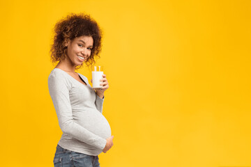 Benefits of dairy products during pregnancy. Pregnant woman holding glass of milk, free space