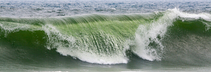 Horizontal view of a wave breaking over its funnel