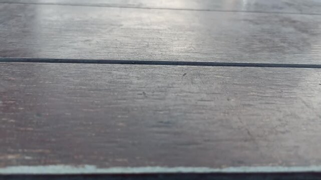 Texture of brown wooden parquet floor with natural pattern close-up. Some of the video is out of focus. Forward movement. Treated wood texture.High quality 4k footage. Close-up texture of Wooden Floor