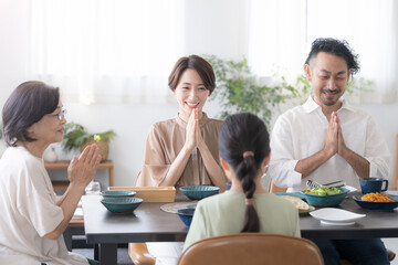 いただきますをする3世代家族の食卓風景