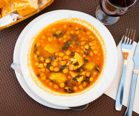 Appetizing stewed chickpeas with cod fish served on plate