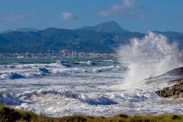 storm off the coast of Mallorca at the end of the tourist season, waves crashing on the shore and flying spray