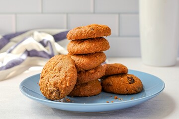 Cookies oatmeal raisin in a blue  plate on white brick background