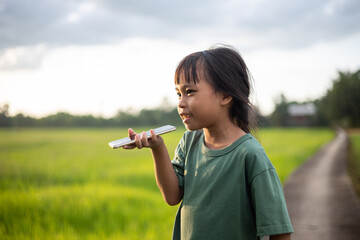 A young girl is smiling and holding a cell
