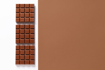 Composition with tasty chocolate bars on color background