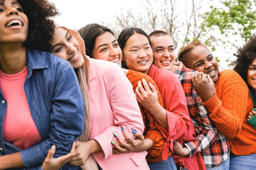 Multicultural, Group of diverse young women friends hugging together at park city. Happy people celebrating party outside