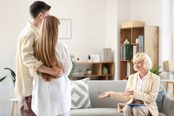 Obraz premium Young couple hugging at psychologist's office, back view