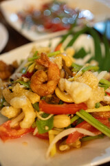 Thai salad with fresh vegetables, seafood and crispy chicken skin. Close up