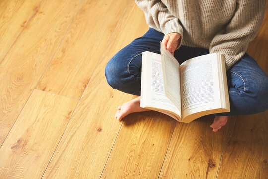 床に座って本を読む女性