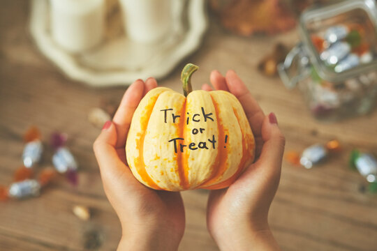 アルファベットが書かれたカボチャを持った女性の手元