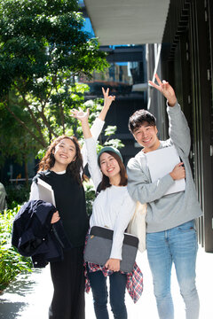 笑顔でポーズをとっている学生3人