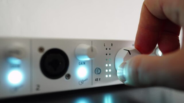 Man rotating a volume knob on an audio interface. Close up