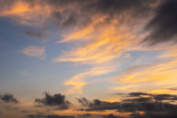 Colorful twilight sky with orange clouds and dark shadows.