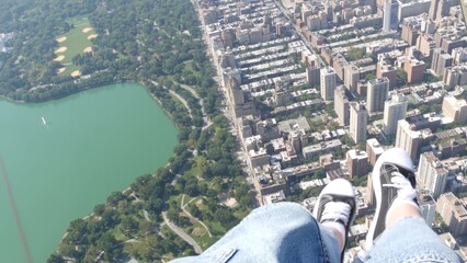 New York City doors off helicopter flight, heli flying over Manhattan, United States. Feet in sneakers, legs in shoes selfie pov. Extreme tourist adventure, travel USA. Camera shaking. Central Park. © Dogora Sun