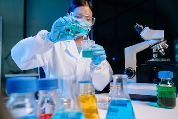Fototapeta premium Scientist mixing chemical liquids in the chemistry lab. Researcher working