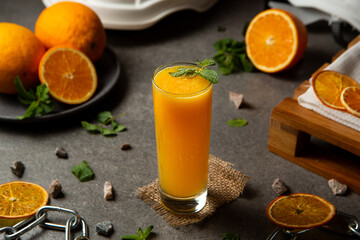 Orange fresh juice with oranges on the table