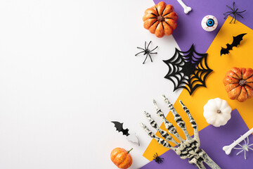 Creative Halloween concept featuring pumpkins, spiderwebs, bats, and a skeleton hand on colorful background. Perfect for festive, spooky, and autumn themes