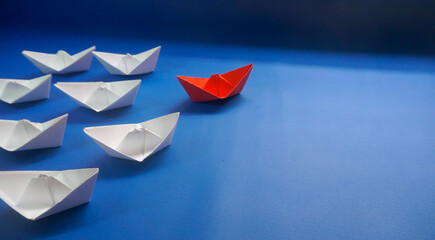 Red Leader Paper Boat Leading Among White Ships On Blue Background In Leadership And Courage Concept