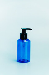 plastic translucent blue bottle isolated on light blue background. template, cosmetic dispenser