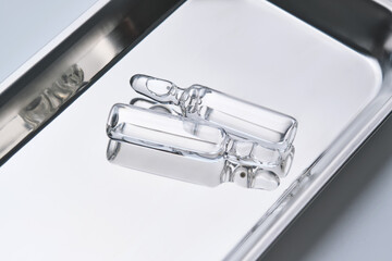 Glass ampoules in a steel medical tray.