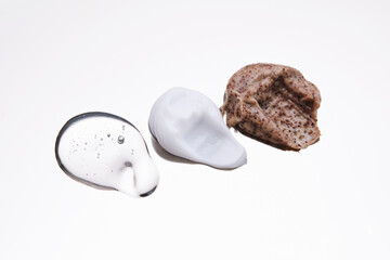 Facial serum, scrub and cream on a stainless steel surface. Texture.