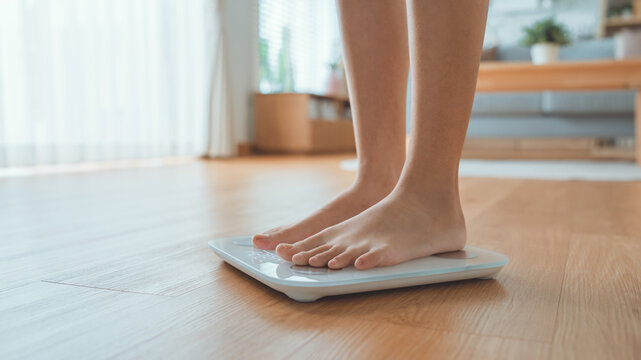 Woman Feet Standing Weighing Scales, Female Checking BMI Weight Loss. Barefoot Measuring Body Fat Overweight