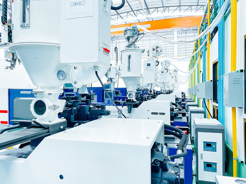 High-tech plastic injection molding machines lined up in a modern factory.