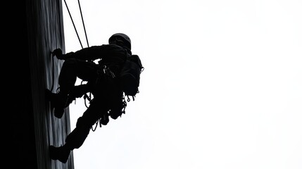 A silhouette of a climber descending a building, showcasing the skill and bravery of rock climbing in an urban environment.