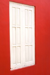retro style white wooden window on a red wall