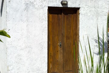 traditional brown wooden door on a white wall with copy space area