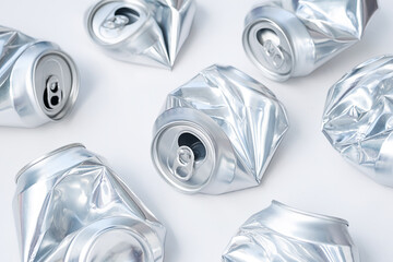 Crushed aluminum cans on white background. Recycling and waste management concepts.