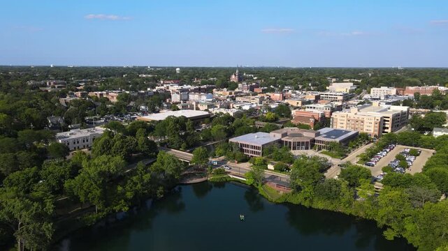 Drone footage of downtown Naperville, IL, featuring buildings, streets, and quarry lake.