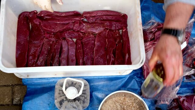 Preparing venison meat with vinegar and spices for curing process, jerky snack