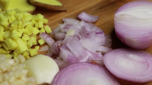 Top view of sliced onion, garlic and ginger on table for cooking. Whole onion, garlic and ginger with pieces. Healthy organic cooking preparation. Chef preparing meal ingredients. 