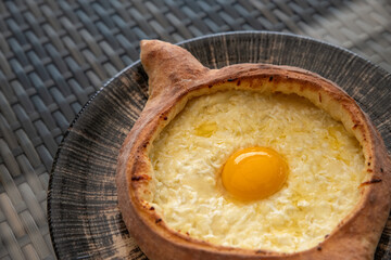 Adjarian khachapuri. Traditional Georgian dish made from a bun with cheese and egg. Selective focus.