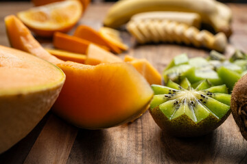 Cut up fruits on a wooden chopping board for school lunch. 