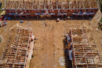 New house under construction, wooden truss system forming roof. Process of building project.