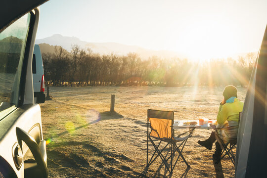 Tourist sit eat breakfast in sunny morning by camper van in official Icelandic campsite while travel on vacation with camper van. Skaftafell campground by glacier in national park