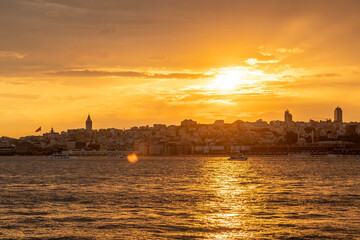 Golden rays of the sun illuminate the Bosphorus as the skyline of Istanbul subtl