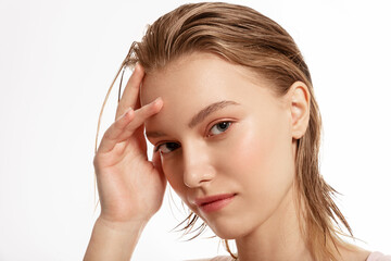 Obraz premium Teenage girl with well-groomed clean skin looks smiling at the camera