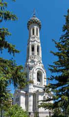 Obraz premium Golden Orthodox cross on multi-colored dome of bell tower glows in sun. Fragment of tower of Cathedral of Our Lady of Kazan (Kazan Cathedral), built on Fortress Hill. Stavropol, Russia - May 23, 2024