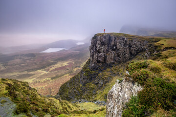 Fototapeta premium Hiker in the mist, Quiraing Valley, Skye, Highlands, Scotland, United Kingdom