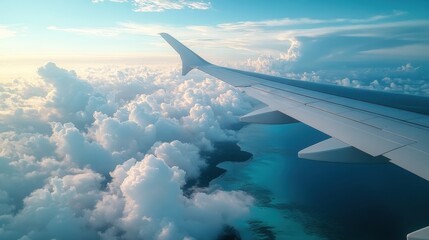 Fototapeta premium A plane is flying through a cloudy sky with a blue ocean below
