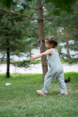 A three-year-old girl runs after pigeons in the park.