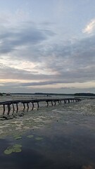 Wooden pier on the river bank in the evening at sunset
