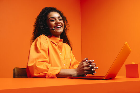 Positive helpdesk operator in vibrant monochromatic workspace, emphasizing creativity and modernity