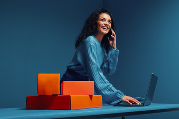 Business woman negotiating on smartphone while working with laptop